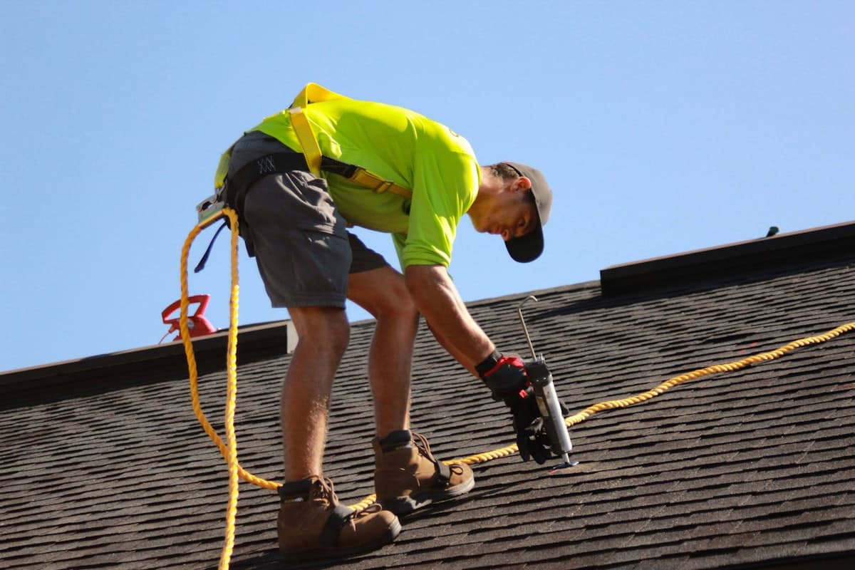 A roofer installing shingles on a residential roof - the kind of project an AllContraX estimate covers